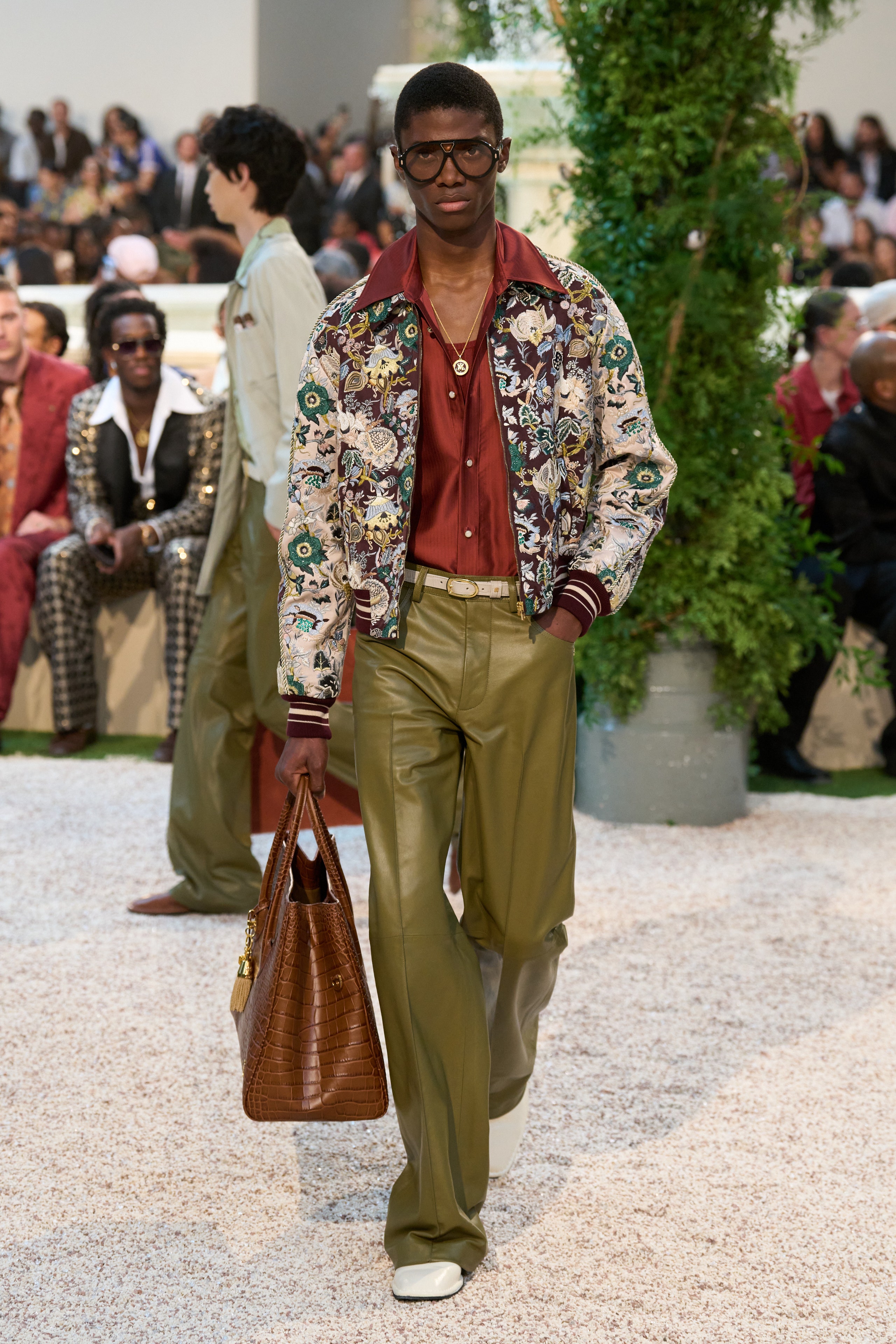 Image may contain Accessories Bag Handbag Clothing Pants Blazer Coat Jacket Adult Person Glasses and Footwear