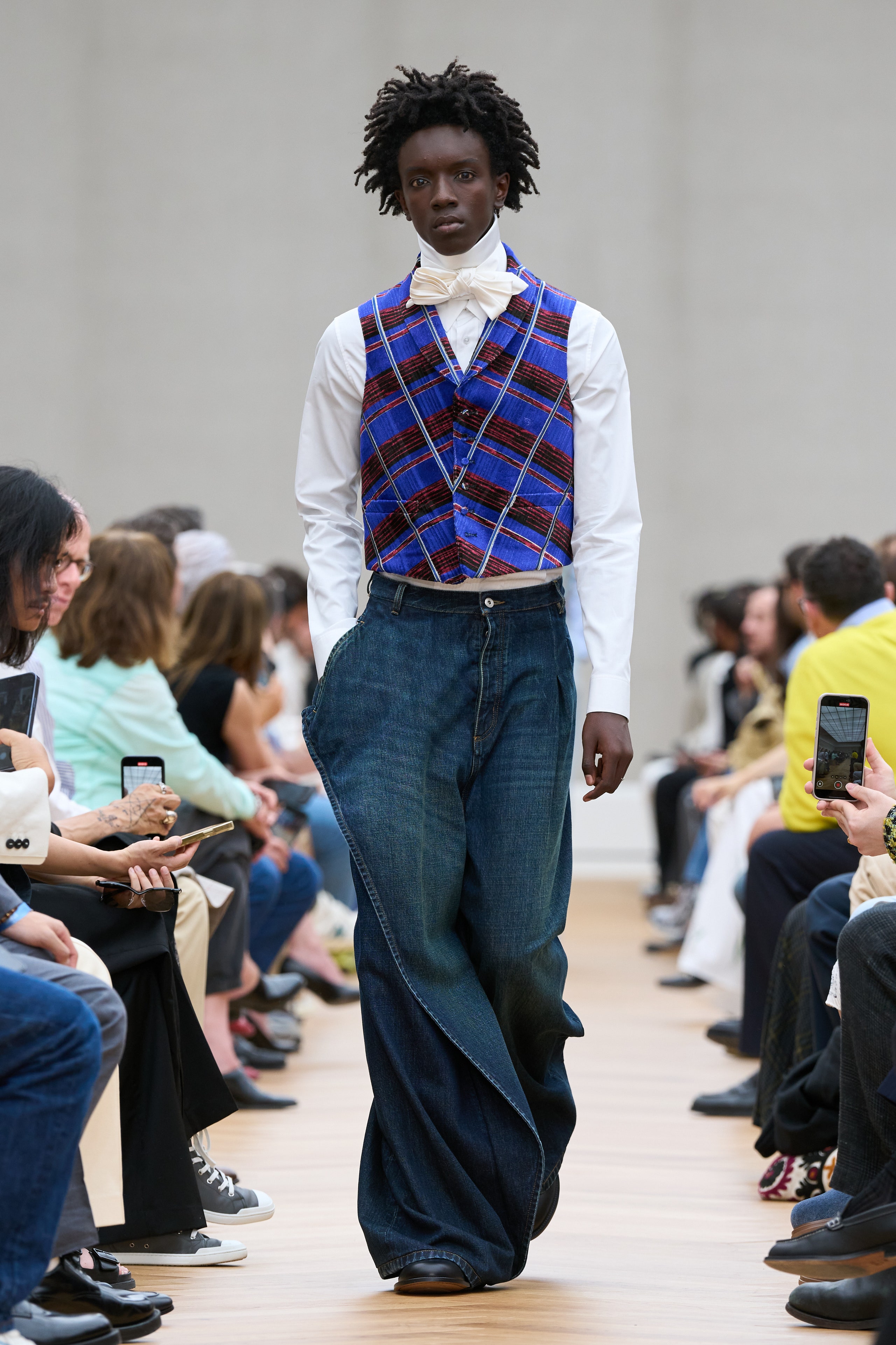 Image may contain Caleb McLaughlin Clothing Pants Electronics Mobile Phone Phone Adult Person Footwear and Shoe